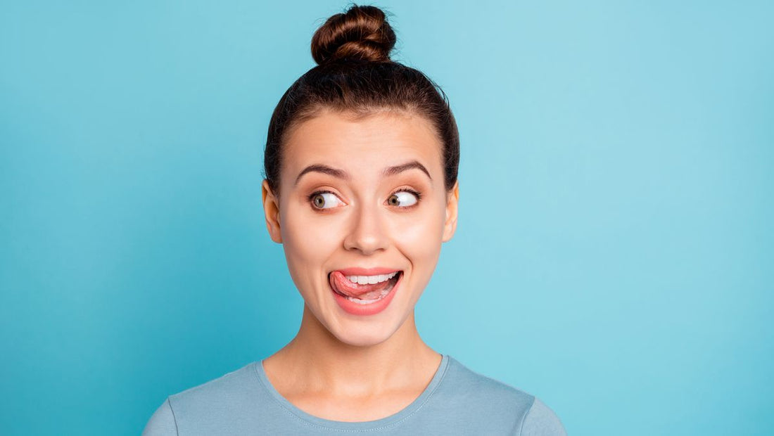 Young woman smiling and preparing for a quick lip routine for busy mornings against a blue background