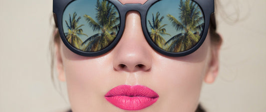 Close-up of woman wearing sunglasses and bright pink heat resistant lip products for summer