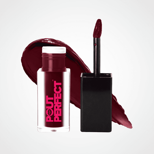 A bottle of Pout Perfect liquid lipstick in a deep berry red shade, shown next to its applicator wand and a matching lipstick smear on a light gray background. Outlandish