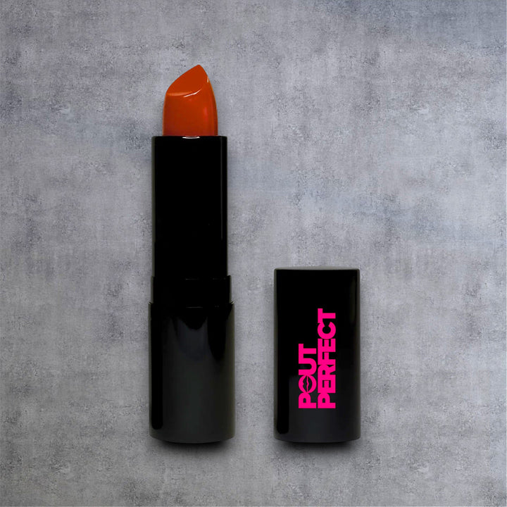 Pout Perfect luxury matte lipstick in sleek black tube with vibrant red shade and cap on gray background