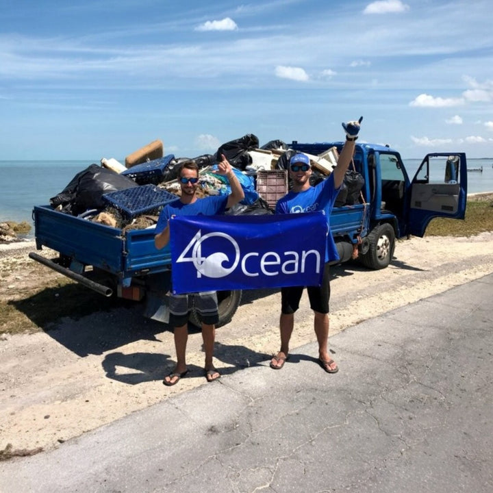 Ecodrive team holding 4Ocean banner beside truck loaded with collected trash for ocean plastic removal services