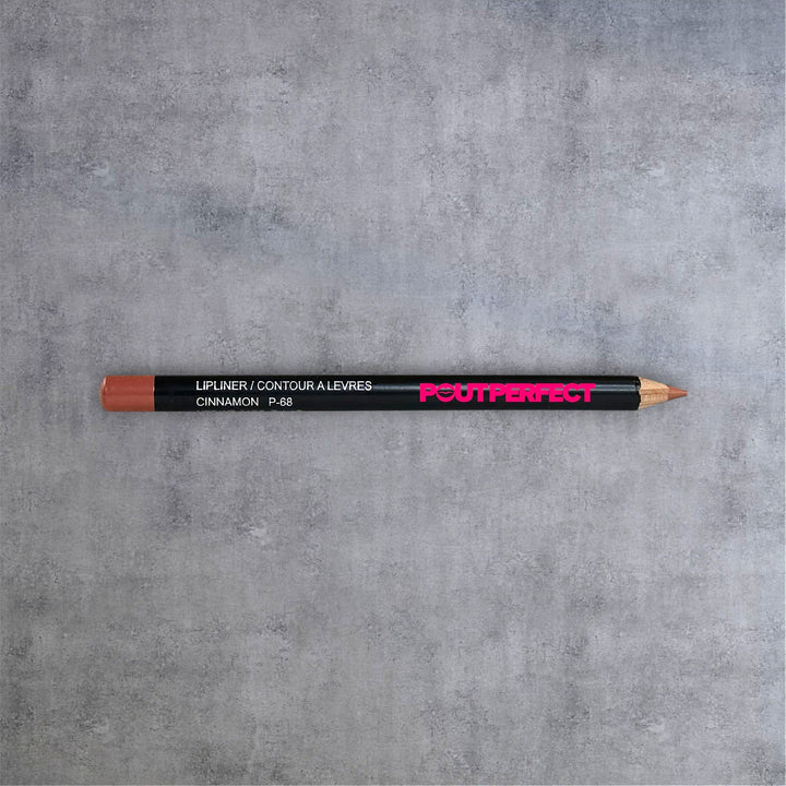 Pout Perfect cinnamon lip liner pencil with black body and brown tip on gray surface